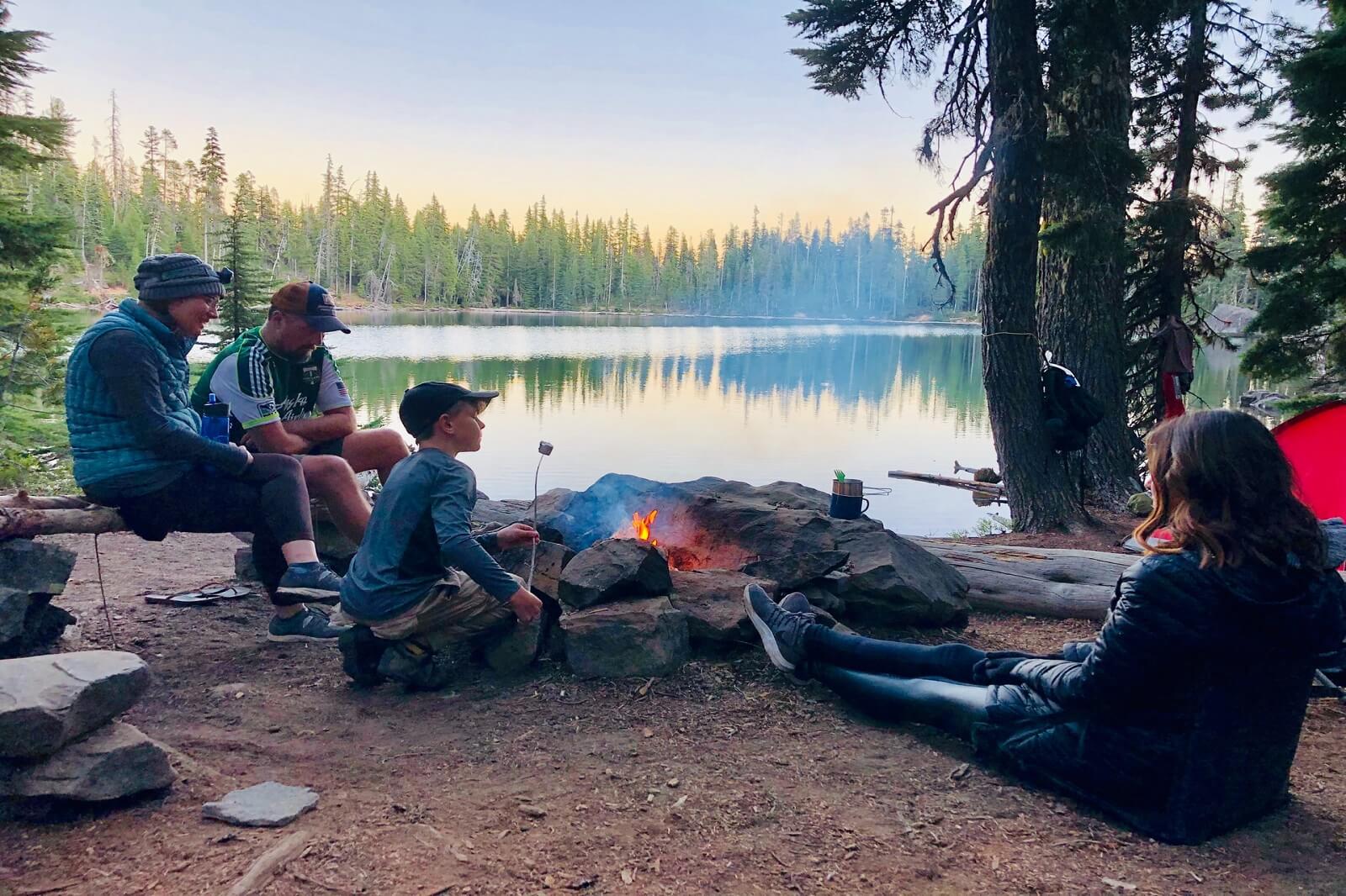 a family is camping near lake inside a tent